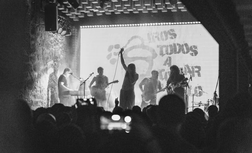 foto en blanco y negro a contraluz, de grupo sobre un escenario