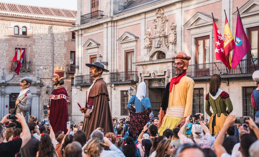 figuras de los gigantes en medio de la multitud de la gente, balcones y banderas institucionales