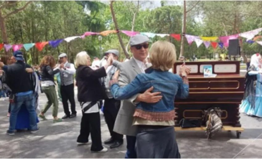 ambiente de verbena, banderines de colores, organillo, parejas de baile