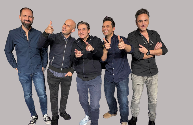 Cinco hombres de pie sobre fondo gris