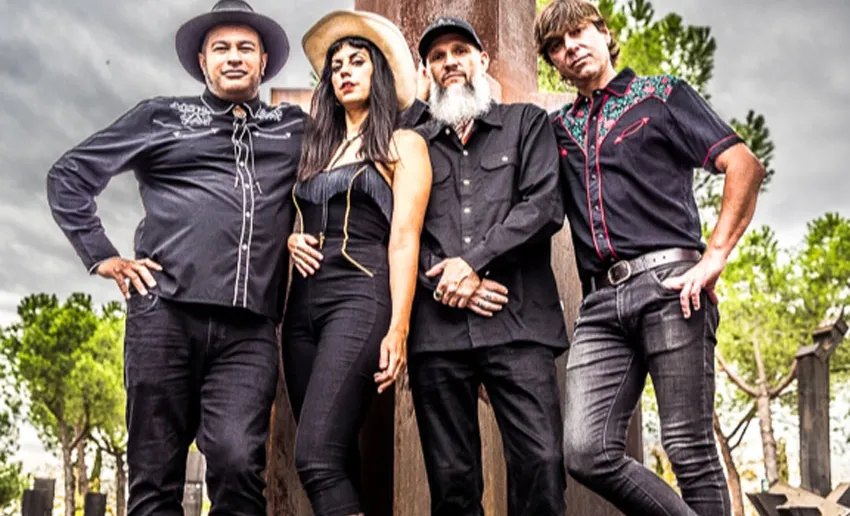 tres hombres y una mujer, todos vestidos de negro, camisas de vaquero y gorro de cowboy