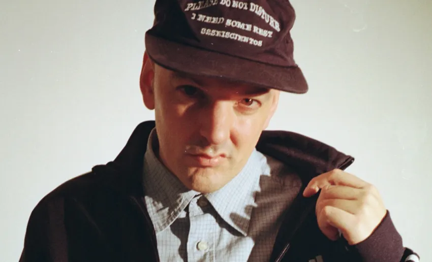 hombre de frente, con gorra, gesto agresivo en su cara, sudadera, y camisa